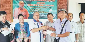  ??  ?? Masir (third left) hands over the government grant to a JKKK member, as others look on.