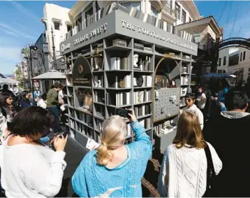  ?? RICHARD VOGEL/AP ?? Fans check out a pop-up to celebrate Taylor Swift’s album “The Tortured Poets Department” on April 17 in LA.