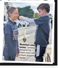  ?? ?? Number one mum Cameron presents his brave mum with a heart-shaped medal