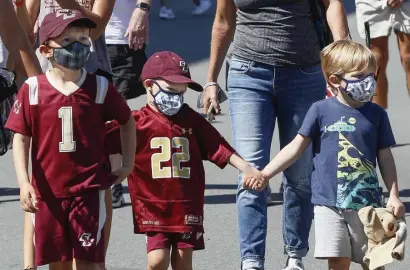  ?? PAUL CONNORS PHOTOS / BOSTON HERALD ?? BEST OFFENSE IS A GOOD DEFENSE: Young Boston College fans, from left, William Hartshorn, 6, his brother Bennet, 3, both of Weston, and their cousin James Allen, 3, of Wilmington, Del., wear masks prior to attending Saturday’s game against Colgate. Below, season ticket holder Steve O’Brien, of Braintree, dons a face covering before the Eagles’ season debut.