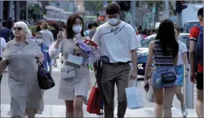  ??  ?? A couple celebrate Valentine’s Day as they wear face masks in precaution of the coronaviru­s outbreak at Orchard Road in Singapore yesterday.