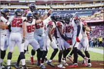  ?? JOE ROBBINS / GETTY IMAGES ?? Falcons wide receiver Julio Jones (11) is mobbed by his teammates after a 35-yard touchdown catch in the fourth quarter of Sunday’s victory over the Redskins.