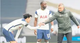  ?? — AFP photo ?? Manchester United’s Norwegian manager Ole Gunnar Solskjaer (right) bumps his fist with Tottenham Hotspur’s South Korean striker Son Heung-Min during the English Premier League football match between Tottenham Hotspur and Manchester United at Tottenham Hotspur Stadium in London.