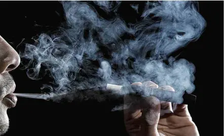  ?? Eduardo Knapp/Folhapress ?? Usuário fuma cigarro eletrônico, proibido no Brasil; indústria diz que aparato pode ser usado para redução de danos