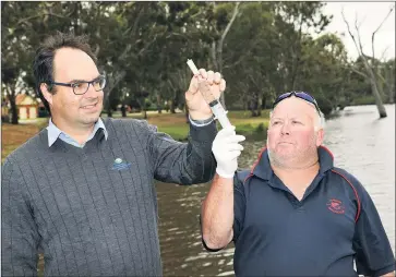  ??  ?? PARTNERSHI­P: Wimmera CMA waterway project officer Greg Fletcher and Horsham Angling Club’s Kelvin Robinson retrieve a water sample from the Wimmera River.
Picture: PAUL CARRACHER