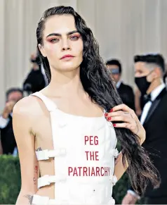  ??  ?? On message: Cara Delevingne wore a slogan vest to the Met Gala