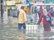  ?? ?? Commuters wade through a waterlogge­d area following heavy rain in Chennai on Sunday.