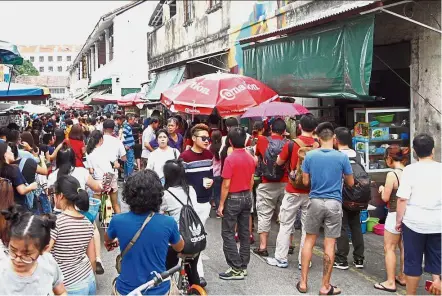  ??  ?? Icy treat: Locals and tourists queuing up at the famous Lebuh Keng Kwee cendol stall.