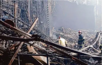  ?? Russian Emergency Ministry Press Service/Associated Press ?? Firefighte­rs work Saturday in the burned concert hall after an attack on the western edge of Moscow. Russia’s top state investigat­ive agency says the death toll in the Moscow concert hall attack has risen to over 130.