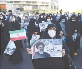  ?? (Majid Asgaripour/WANA via Reuters) ?? AN IRANIAN woman holds a picture of presidenti­al candidate Ebrahim Raisi during an election rally in Tehran last week.