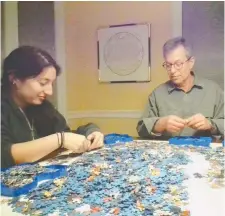  ?? DAVID LESCHINSKY ?? The owner of Eureka! Puzzles, David Leschinsky, right, tackled the Snow White and the Seven Dwarfs section of the massive Disney puzzle with his daughter, Maya.