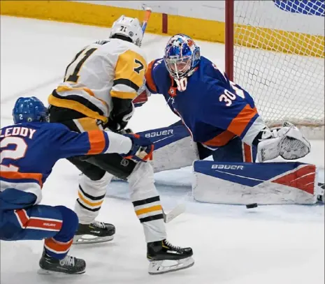  ?? Peter Diana/Post-Gazette ?? As he did so often in the series, Islanders goaltender Ilya Sorokin makes a save, this one on Evgeni Malkin Wednesday night in Game 6 in Uniondale, N.Y.