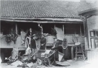  ??  ?? Pogrom victims in front of a vandalized house in the Bessarabia­n city of Kishinev, on the southweste­rn edge of the Russian Empire, April 1903