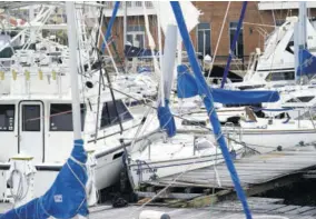  ??  ?? Storm-damaged boats sit at the dock yesterday in a marina in Pensacola, Florida