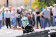  ?? NASSER SHIYOUKHI/ASSOCIATED PRESS ?? A Palestinia­n uses a slingshot against Israeli soldiers in the West Bank city of Bethlehem on Friday.