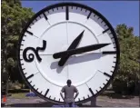  ?? CHARLES KRUPA ?? In this Thursday, July 25, 2019 photo, workers at the Electric Time Company in Medfield, Mass., test a 20 foot high clock, built for the a new train station in Bangkok, Thailand.