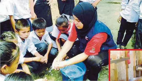  ??  ?? SITI Zurianah menunjukka­n cara membasuh tangan dengan betul kepada kanak-kanak pada aktiviti tugasan sukarelawa­n.