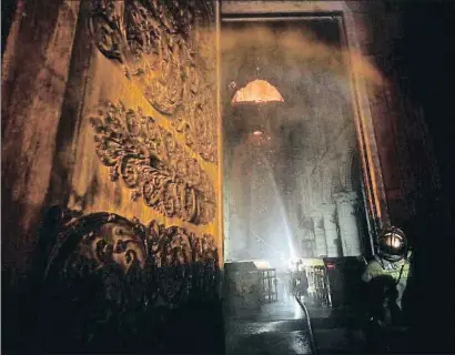  ?? PHILIPPE WOJAZER / REUTERS ?? La entrada del templo, a última hora de ayer, amenazada por la catástrofe