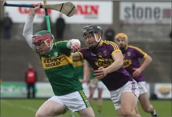  ??  ?? Wexford midfielder Jack O’Connor tries to halt the progress of Kerry defender Seán Weir.