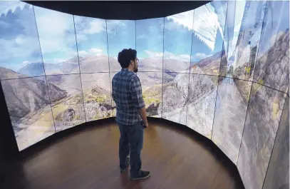  ?? ADOLPHE PIERRE-LOUIS/JOURNAL ?? Isaac Valdez looks at the Immersive Video Wall during a tour of Ideum’s facility in 2018. The company is preparing to debut an “add on” that will make its displays contact-free.