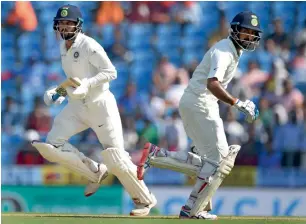  ?? AFP ?? Vijay (left) and Pujara made sure India ram home the advantage from day one as they recorded their fifth century stand in their last seven Test innings together. — > Sri Lanka 1st innings > India 1st innings