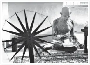  ?? NATIONAL GANDHI MUSEUM ?? ■ A 1946 photograph of Gandhi taken by Margaret Bourke-White shows him reading clippings with a charkha in the foreground.