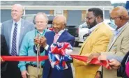  ?? EHSAN KASSIM/THE GADSDEN TIMES VIA AP ?? Educator and athlete Clarence Underwood Jr. cuts the ribbon before unveiling a sign renaming the across from the Gadsden Library after him on Oct. 5 in Gadsden, Ala.