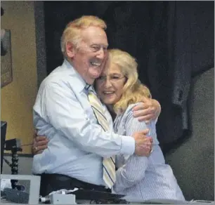  ?? Jae C. Hong Associated Press ?? SCULLY with wife Sandi in 2014 at Dodger Stadium. Scully was left with three children after his first wife, Joan, died in 1972. The Scully family eventually grew to six children.