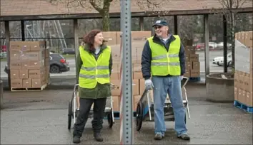  ?? Emily Matthews/Post-Gazette ?? Kathee Kuvinka, of Point Breeze, and Gregory Mittereder, both volunteers for the Greater Pittsburgh Community Food Bank, talk as they prepare to load boxes of food into cars on Monday in the Kennywood parking lot in West Mifflin.