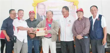  ??  ?? Pairin receiving PBS membership forms from Kampung Mangi Pangi JKKK chairman Yatik Mulitin at the event. Also seen are Daniel (third right), Lawrence (second right),Thomas (left) and Silverius (third left).