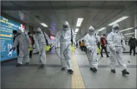  ?? KIM SUN-WOONG — THE ASSOCIATED PRESS ?? Workers wearing protective gears disinfect as a precaution against the new coronaviru­s at the subway station in Seoul, South Korea, on Wednesday, March 11.