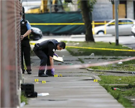  ?? PHOTO AFP ?? Des enquêteurs de la police de Chicago passent au peigne fin l’une des scènes de fusillade ce week-end.