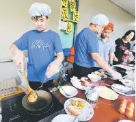  ??  ?? MAHIR: Peserta pameran sedang memasak inti burger.