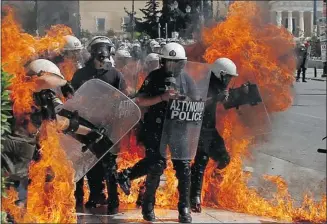  ?? Nikolas Giakoumidi­s/the Associated Press ?? A fire bomb hits police during clashes in Athens on Wednesday at a demonstrat­ion against austerity measures.