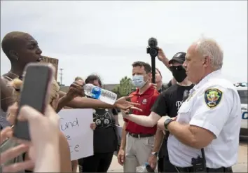  ?? Lily LaRegina/Post-Gazette ?? Protesters briefly argue with Monroevill­e Police Chief Doug Cole on Tuesday while marching down William Penn Highway in Monroevill­e.