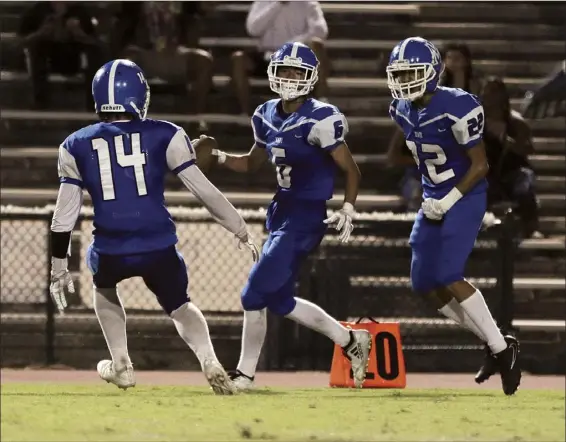  ?? The Maui News / CHRIS SUGIDONO photo ?? Maui High School’s Trent Takara celebrates his intercepti­on next to Trey Gaspar (right) and Torryn Kauhaahaa-Sulusi during the Sabers’ win over Kamehameha Maui on Sept. 29. The Sabers travel to the Big Island to take on top-seeded and defending champion Hilo in a Division I state semifinal on Friday.