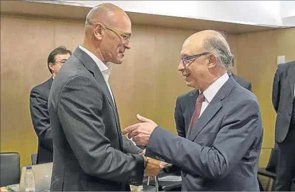  ?? DANI DUCH ?? Cristóbal Montoro saluda al conseller de Afers i Relacions Institucio­nals de la Generalita­t, Raül Romeva, al iniciarse el encuentro