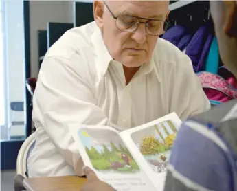  ?? PHOTO BY JOHN W. FOUNTAIN ?? Michael Brown, 69, of Richton Park, reads to a student in the “Real Men Read” program at south suburban Matteson Elementary School.