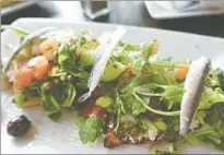  ??  ?? FRESH catches and veggies are arrayed on the plates at Local Ocean Seafood across from the harbor in Newport, Ore.