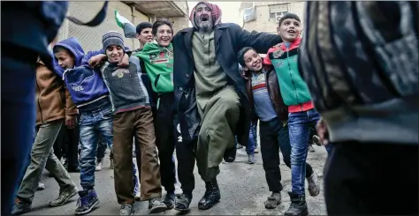  ?? AFP ?? TRUCE IN SYRIA: Syrian men dance during a demonstrat­ion against the Syrian regime in the rebel-held town of Saqba, on the eastern outskirts of the capital Damascus, on Friday, on the first day of a nationwide truce. Clashes erupted between Syrian...