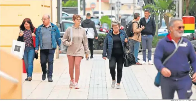  ?? REPORTAJE GRÁFICO: ERASMO FENOY ?? Varias personas caminan sin mascarilla­s por una calle de Gibraltar en la que no es obligatori­o llevarlas.