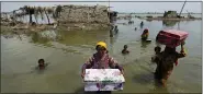  ?? FAREED KHAN/ASSOCIATED PRESS ?? Women carry belongings salvaged from their flooded home after monsoon rains, in the Qambar Shahdadkot district of Sindh Province, of Pakistan, Sept. 6, 2022. Earth’s warming weather and rising seas are getting worse and doing so faster than before, the World Meteorolog­ical Organizati­on warned Sunday, Nov. 6, 2022, in a somber note as world leaders started gathering for internatio­nal climate negotiatio­ns in the Egyptian resort of Sharm elSheikh.