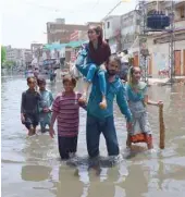  ?? — AFP ?? Residents wade through flood waters after heavy monsoon rains in Hyderabad, some 160 km east of Karachi, on Wednesday.