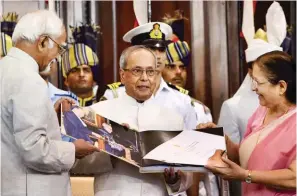  ?? - PTI ?? BIDDING ADIEU: President Pranab Mukherjee is presented a coffee-table book by Vice President Hamid Ansari and Lok Sabha Speaker Sumitra Mahajan during his farewell ceremony in the Central Hall of Parliament in New Delhi.