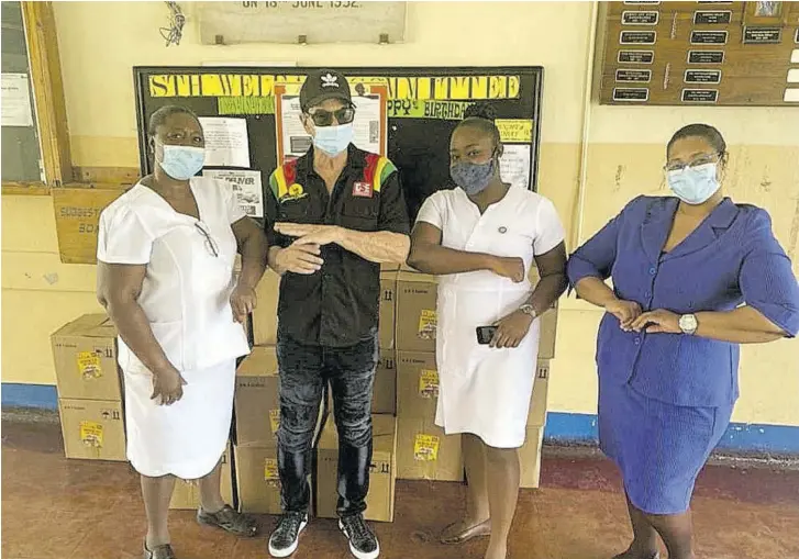  ??  ?? Joe Bogdanovic­h (centre), CEO of Downsound Entertainm­ent, poses with staff of the Spanish Town Hospital.
