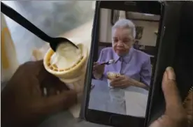  ??  ?? Veney snaps a picture of her mother eating ice cream. Veney says she is very cognizant of the parallels between adults with dementia and children: both thrive on routine.