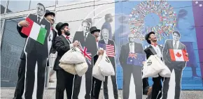  ?? AFP ?? Activists dressed as ‘debt collectors’ hold cutouts of the leaders of Italy, the UK, the US, Australia, and Canada during a protest at the IMF headquarte­rs in Washington DC this week.