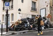  ?? ASSOCIATED PRESS ?? A woman covers her nose in Paris on Monday as strikes continue and uncollecte­d garbage piles higher by the day.