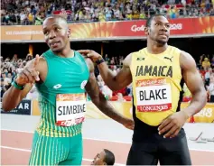  ??  ?? South Africa’s Akani Simbine celebrates his victory with Jamaica’s Yohan Blake after the men’s 100m final. — AFP photo