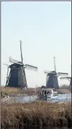  ?? AP/PETER DEJONG ?? Windmills lining the Hooge Boezem van de Overwaard canal at the UNESCO World Heritage site in Kinderdijk, Netherland­s, are major draws for tourists.